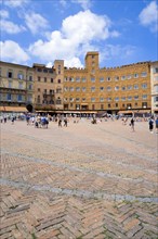 ITALY, Tuscany, Siena, Piazza del Campo and surrounding buildings under a blue sky and busy with
