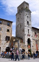 ITALY, Tuscany, San Gimignano, Tourists gathering at the well in Piazza della Cisterna in front of