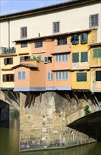 ITALY, Tuscany, Florence, Ponte Vecchio medieval bridge across River Arno with view of merchant's