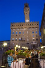 ITALY, Tuscany, Florence, People dining at restaurant tables outdoors at night in the Piazza della