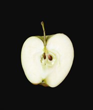 Food, Fruit, Apples, One single ripe green apple cut in half against a black background showing the