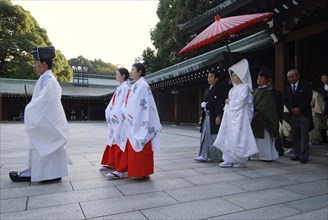 Japan, Tokyo, Yoyogi, Meiji Jingu shrine, a wedding party led by a shinto priest and two woman