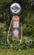 IRELAND, County Kerry, Lauragh Village, Murphys stout sign affixed to old petrol pump with advert