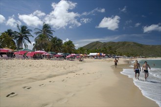 VENEZUELA, Margarita Island, Playa Caribe, View of exotic beach with people walking on the sand