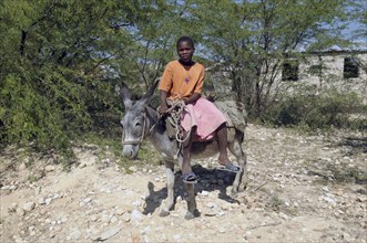 Haiti, Isla de Laganave, Girl sat on Donkey.