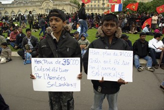 France, Paris, Esplanade des Invalides,Two boys stand in front of a protest of Tamil Tiger