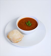 Food, Cooked, Soup, Bowl of tomato and basil soup on a plate with a rustic bread roll on a white