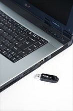 Industry, Computers, Components, 8 gigabyte portable USB flash drive storage device beside laptop