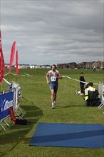 England, West Sussex, Goring-by-Sea, Worthing Triathlon 2009, male competitor approaching finish
