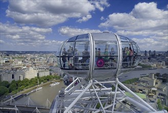England, London, Southbank, London Eye capsule with passengers visible in capsule with the City in