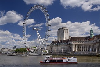 England, London, South Bank, London Eye and Aquarium from Westminster Bridge with tourist boat in