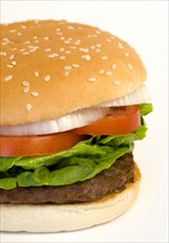 Food, Cooked, Hamburger, Single quarter pound burger with onoin tomato and lettuce in a bun on a