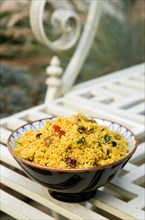Food, Cooked, Pasta, Bowl of Moroccan couscous with fruit nuts and vegetables on a metal table in a