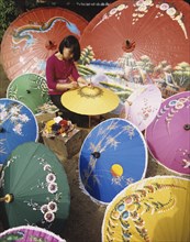 Thailand, Local woan painting traditional umbrellas.