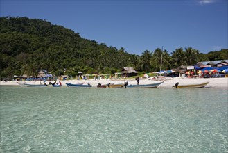 Malaysia, Pulau Perhentian, Terrengganu, Pulau Perhentian Kecil coast with boats shops umbrellas on