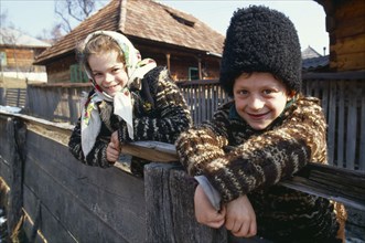 Romania, Maramuresh, Portrait of two local children wearing traditional clothing leaning over