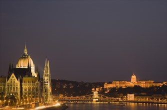 Hungary, Budapest, View along the River Danube at night with the Parliament building on the left,