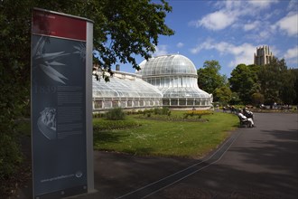 Ireland, Northern, Belfast, Botanic Gardens with people sat on benches outside the Palm House next