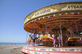 England, East Sussex, Brighton, Carousel on the pebble beach promenade.
