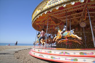 England, East Sussex, Brighton, Carousel on the pebble beach promenade.