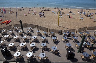 England, East Sussex, Brighton, view over tables outside seafront bar under the promenade.