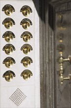 Venice, Veneto, Italy. Brass doorbells with nameplates on restored facade of apartment building