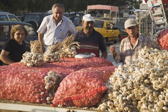 Kusadasi, Aydin Province, Turkey. Stallholder selling garlic at weekly market standing behind stall