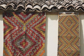 Selcuk, Izmir Province, Turkey. Kilims hanging up to dry in sunshine on walls of village house.