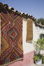 Selcuk, Izmir Province, Turkey. Kilim hanging up to dry in sun from wall of village house. Turkey