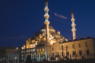 Istanbul, Turkey. Sultanahmet. The New Mosque or Yeni Camii at dusk with illuminated sign which