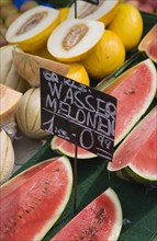 Vienna, Austria. The Naschmarkt. Display of different types of melon for sale on stall with cut