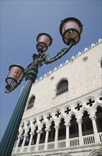Venice, Veneto, Italy. Decorative street lamp in front of partly seen facade of the Palazzo Ducale