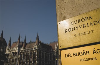 Budapest, Pest County, Hungary. Hungarian language signs on corner of office building in foreground