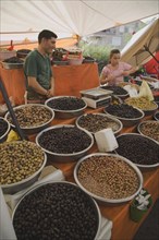 Kusadasi, Aydin Province, Turkey. Stall at weekly market selling olives and nuts with male stall