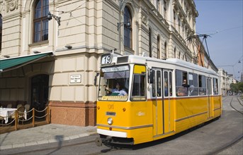 Budapest, Pest County, Hungary. Tram with female driver in street on bank of the River Danube Buda