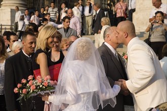 Budapest, Pest County, Hungary. Bride and groom greeting wedding guests on steps of Saint Stephens