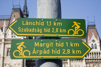 Budapest, Pest County, Hungary. Green and yellow signs indicating direction of cycle lanes outside