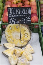 Vienna, Austria. The Naschmarkt. Jack Fruit for sale on fruit stall cut in half and into wedges.