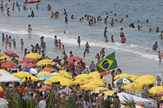 Rio de Janeiro, Brazil. Copacabana beach. Crowds on the beach and in the sea bikinis multi-coloured
