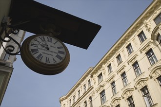 Vienna, Austria. Clock and watchmaker sign with part seen exterior facade of Empire era building
