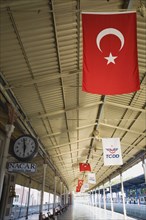 Istanbul, Turkey. Sultanahmet. View along railway platform with Turkish flags hanging from the roof