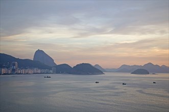 Rio de Janeiro, Brazil. Copacabana and Sugarloaf Mountain at dawn with fishing boats in the bay