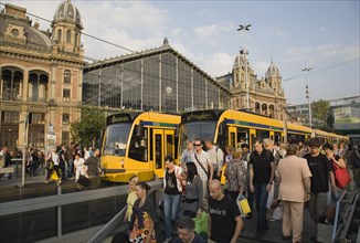 Budapest, Pest County, Hungary. Trams and crowd of passengers in front of rail terminus Budapest