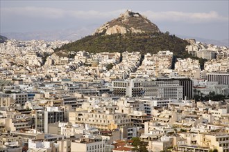 Athens, Attica, Greece. Mount Lycabettus rising in central Athens with densely populated city below
