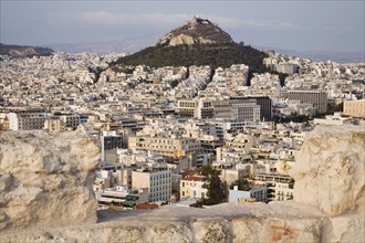 Athens, Attica, Greece. Mount Lycabettus rising in central Athens with densely populated city below