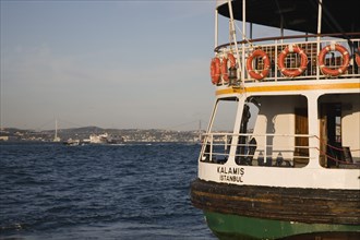 Istanbul, Turkey. Sultanahmet. Ferry flying Turkish flag on the Bosphorous with bridge behind.