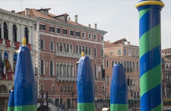 Venice, Veneto, Italy. Green yellow and blue painted poles of gondola station from Rialto bridge