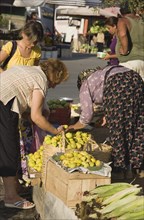 Kusadasi, Aydin Province, Turkey. Woman from local farm selling fruit and vegetables to shoppers at