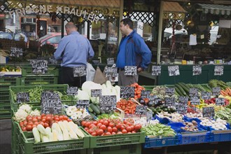 Vienna, Austria. The Naschmarkt. Stallholder and customer standing behind display of fresh produce