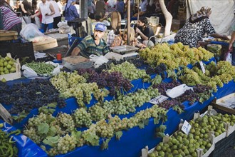 Kusadasi, Aydin Province, Turkey. Stall with display of grapes figs beans and chilies for sale in